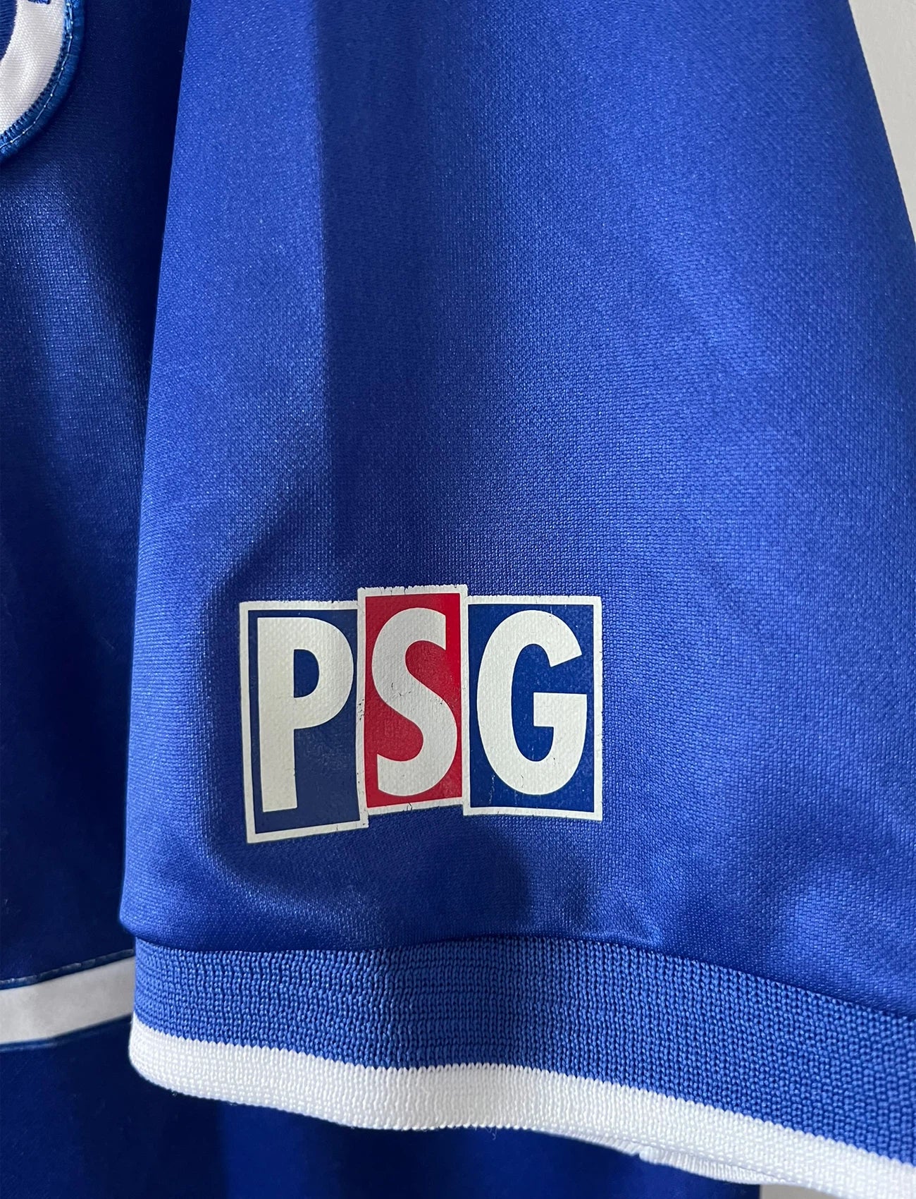Maillot de foot vintage domicile blanc et rouge du PSG 1999/2000. On peut retrouver l'équipementier Nike et le sponsor Opel. Il s'agit d'un maillot authentique d'époque.