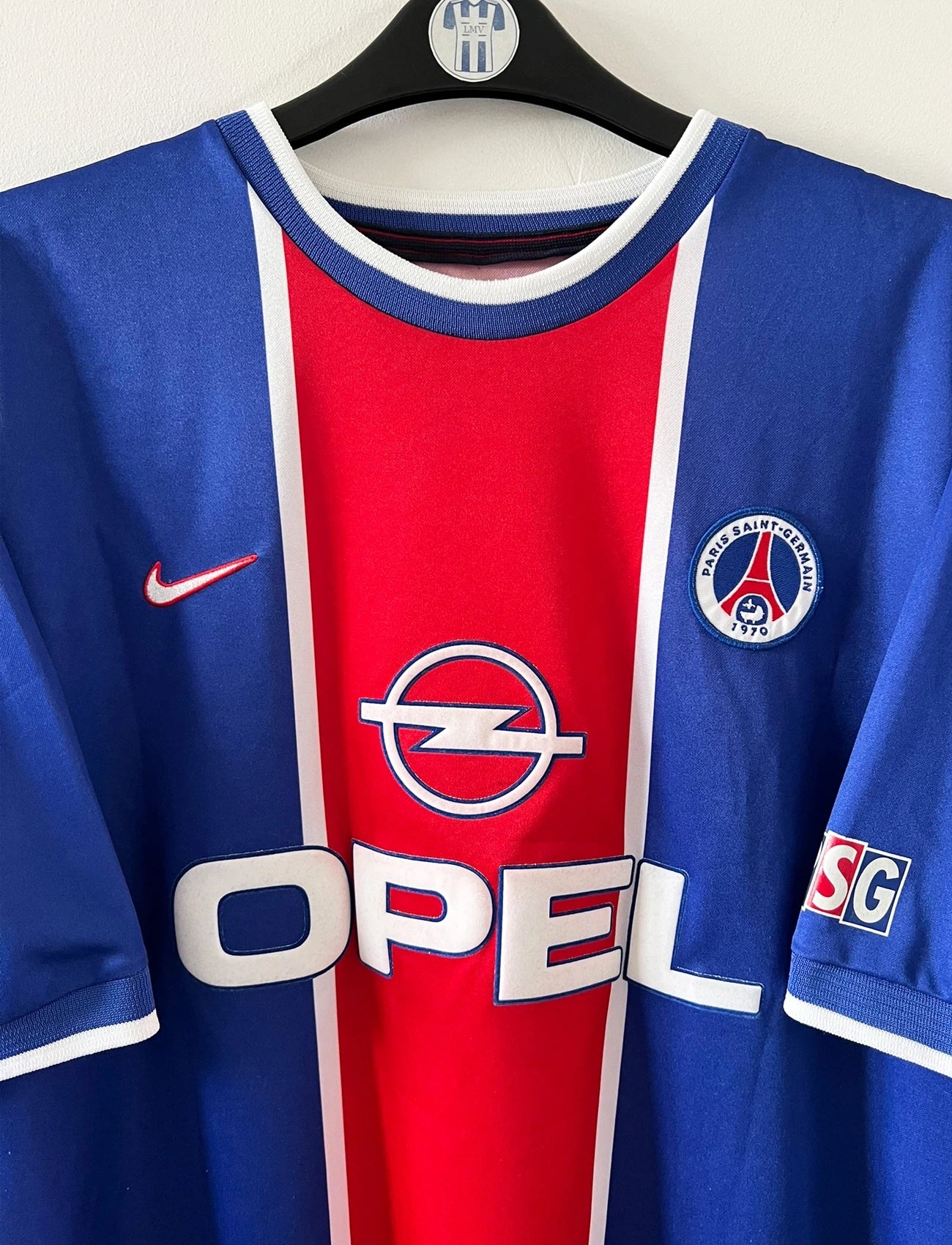 Maillot de foot vintage domicile blanc et rouge du PSG 1999/2000. On peut retrouver l'équipementier Nike et le sponsor Opel. Il s'agit d'un maillot authentique d'époque.