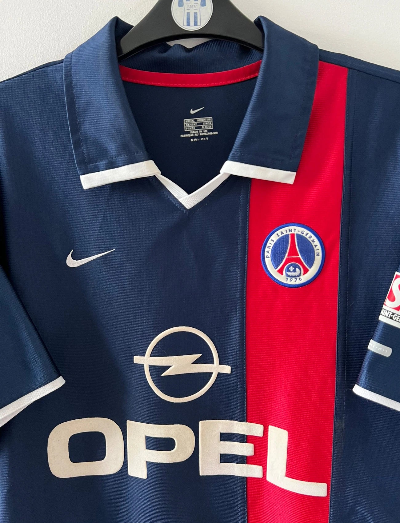 Maillot de foot vintage domicile bleu et rouge du PSG 2001/2002. On peut retrouver l'équipementier Nike et le sponsor Opel. Il s'agit d'un maillot authentique d'époque.