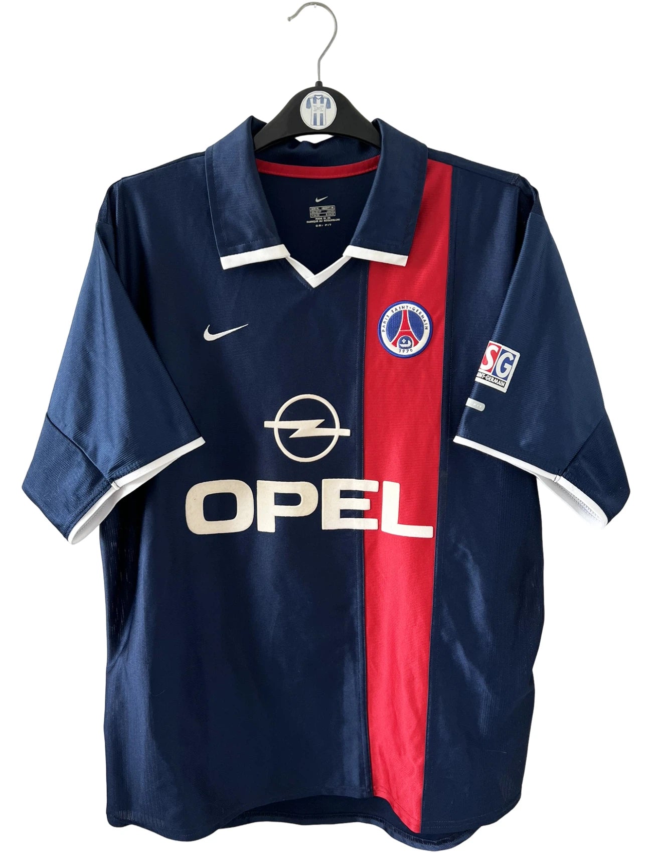 Maillot de foot vintage domicile bleu et rouge du PSG 2001/2002. On peut retrouver l'équipementier Nike et le sponsor Opel. Il s'agit d'un maillot authentique d'époque.