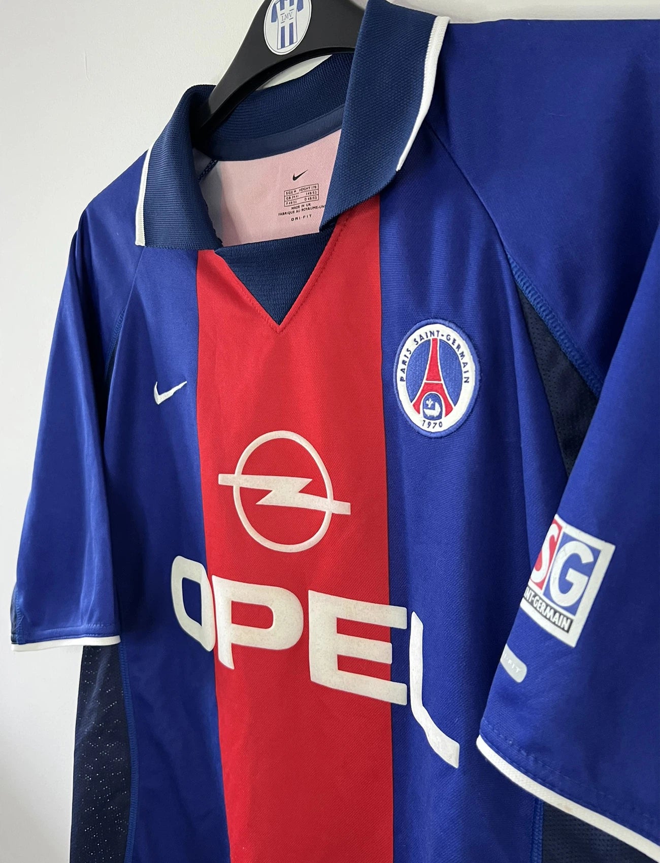 Maillot de foot vintage domicile du PSG rouge et bleu de la saison 2000/2001. On peut retrouver l'équipementier Nike et le sponsor Opel. Il s'agit d'un maillot authentique d'époque