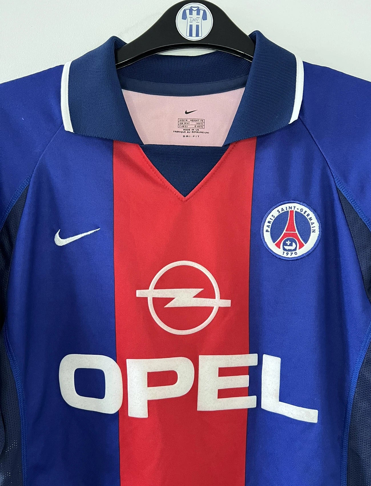 Maillot de foot vintage domicile du PSG rouge et bleu de la saison 2000/2001. On peut retrouver l'équipementier Nike et le sponsor Opel. Il s'agit d'un maillot authentique d'époque