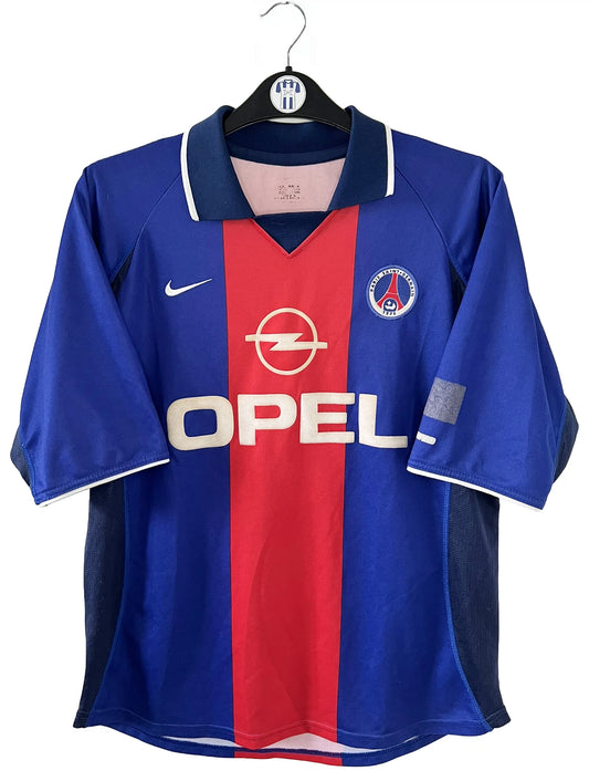 Maillot de foot vintage domicile du PSG de la saison 2000/2001. Le maillot est de couleur bleu et rouge. On peut retrouver l'équipementier nike et le sponsor OPEL