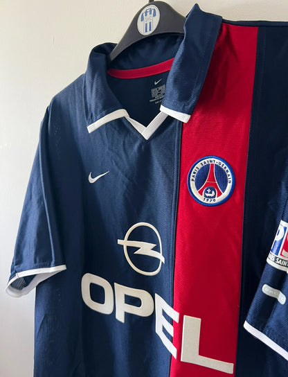 Maillot de foot vintage domicile bleu du PSG de la saison 2001/2002. On peut retrouver l'équipementier Nike et le sponsor Opel. Il s'agit d'un maillot authentique d'époque.