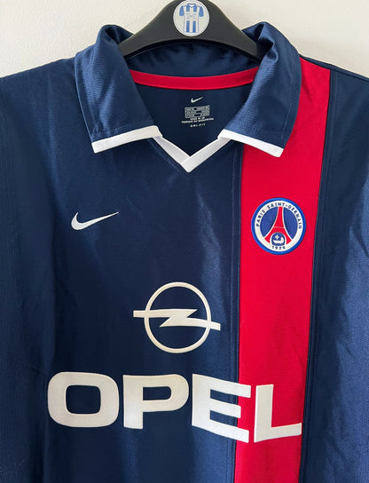 Maillot de foot vintage domicile bleu du PSG de la saison 2001/2002. On peut retrouver l'équipementier Nike et le sponsor Opel. Il s'agit d'un maillot authentique d'époque.