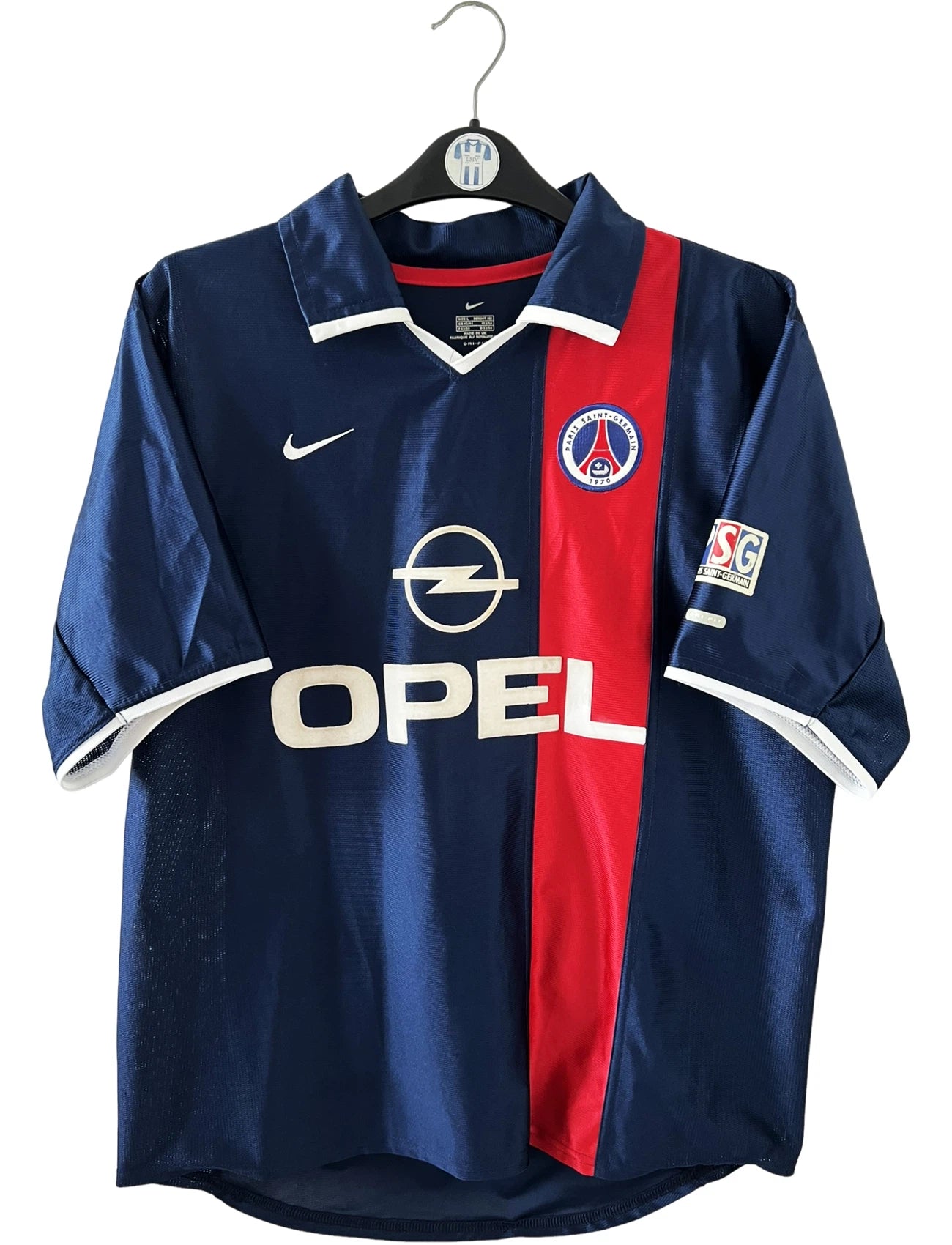 Maillot de foot vintage domicile bleu du PSG 2001/2002. On peut retrouver l'équipementier Nike et le sponsor Opel. Le maillot est floqué du numéro 11 Alex. Il s'agit d'un maillot authentique d'époque.