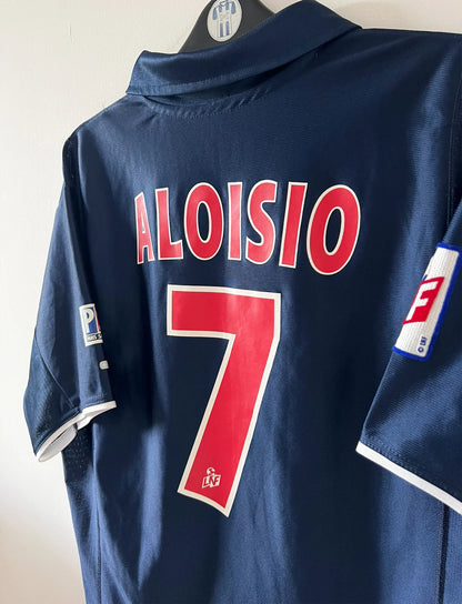 Maillot de foot vintage domicile bleu du PSG 2001/2002. On peut retrouver l'équipementier Nike et le sponsor Opel. Le maillot est floqué du numéro 7 Aloisio. Il s'agit d'un maillot authentique d'époque.