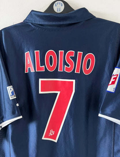 Maillot de foot vintage domicile bleu du PSG 2001/2002. On peut retrouver l'équipementier Nike et le sponsor Opel. Le maillot est floqué du numéro 7 Aloisio. Il s'agit d'un maillot authentique d'époque.
