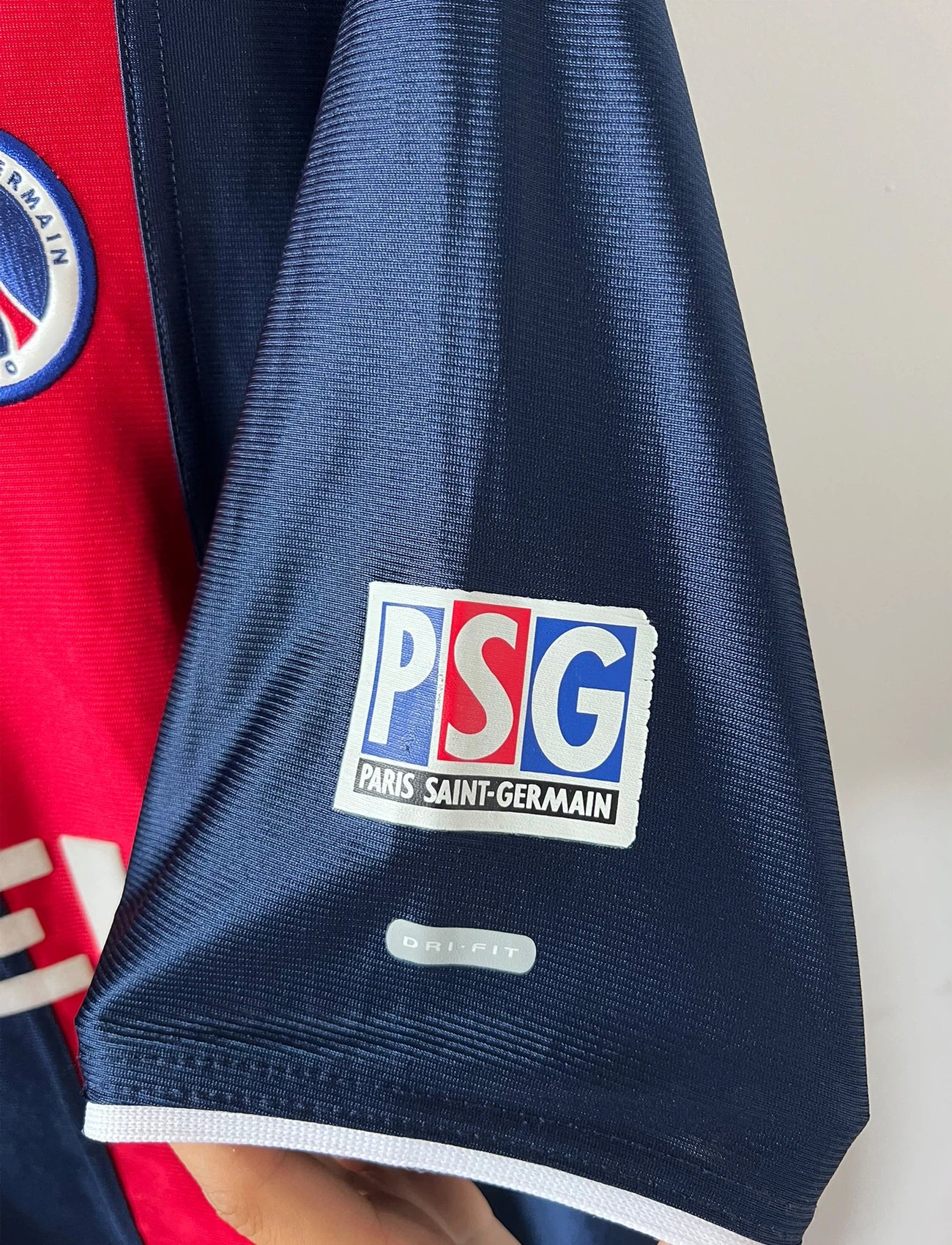Maillot de foot vintage domicile bleu du PSG 2001/2002. On peut retrouver l'équipementier Nike et le sponsor Opel. Le maillot est floqué du numéro 7 Aloisio. Il s'agit d'un maillot authentique d'époque.