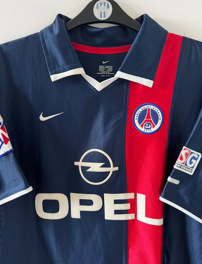 Maillot de foot vintage domicile bleu du PSG 2001/2002. On peut retrouver l'équipementier Nike et le sponsor Opel. Le maillot est floqué du numéro 7 Aloisio. Il s'agit d'un maillot authentique d'époque.