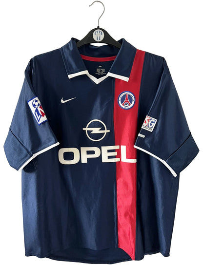 Maillot de foot vintage domicile bleu du PSG 2001/2002. On peut retrouver l'équipementier Nike et le sponsor Opel. Le maillot est floqué du numéro 7 Aloisio. Il s'agit d'un maillot authentique d'époque.