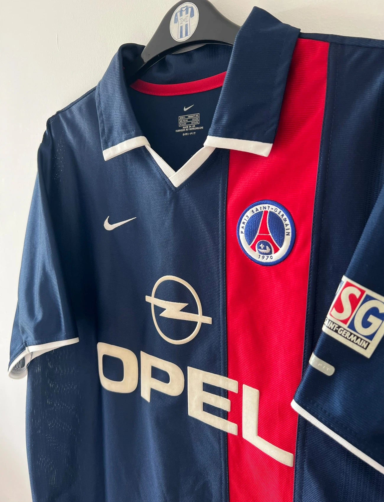 Maillot de foot vintage domicile bleu du PSG 2001/2002. On peut retrouver l'équipementier Nike et le sponsor Opel. Il s'agit d'un maillot authentique d'époque.
