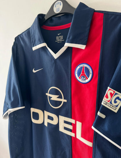 Maillot de foot vintage domicile bleu du PSG 2001/2002. On peut retrouver l'équipementier Nike et le sponsor Opel. Il s'agit d'un maillot authentique d'époque.