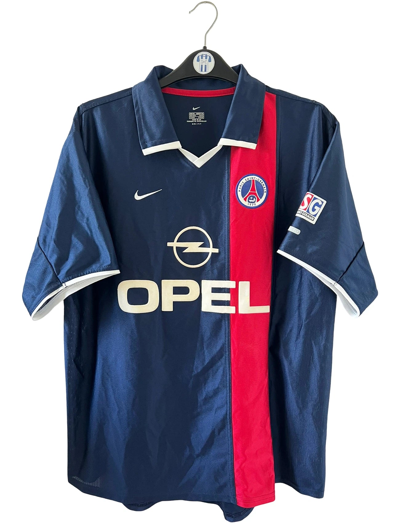 Maillot de foot vintage domicile bleu rouge et blanc du PSG de la saison 2001/2002. On peut retrouver l'équipementier nike et le sponsor Opel. Il s'agit d'un maillot authentique d'époque.