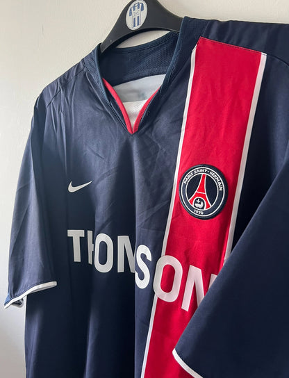 Maillot de foot vintage domicile rouge et bleu du PSG de la saison 2003/2004. On peut retrouver l'équipementier Nike et le sponsor Thomson. Il s'agit d'un maillot authentique d'époque.