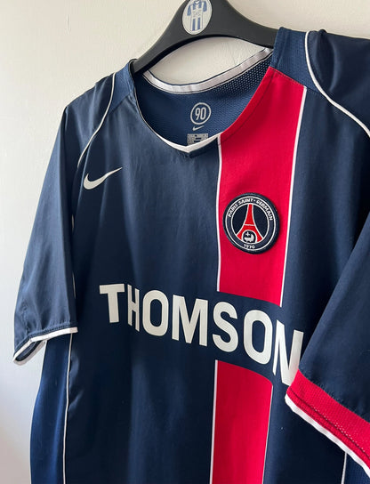 Maillot de foot vintage domicile bleu et rouge du PSG 2004/2005. On peut retrouver l'équipementier Nike et le sponsor Thomson. Il s'agit d'un maillot authentique d'époque.