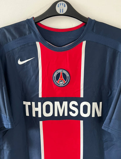 Maillot de foot vintage domicile bleu et rouge du PSG de la saison 2005/2006. On peut retrouver l'équipementier Nike et le sponsor Thomson. Il s'agit d'un maillot authentique d'époque.