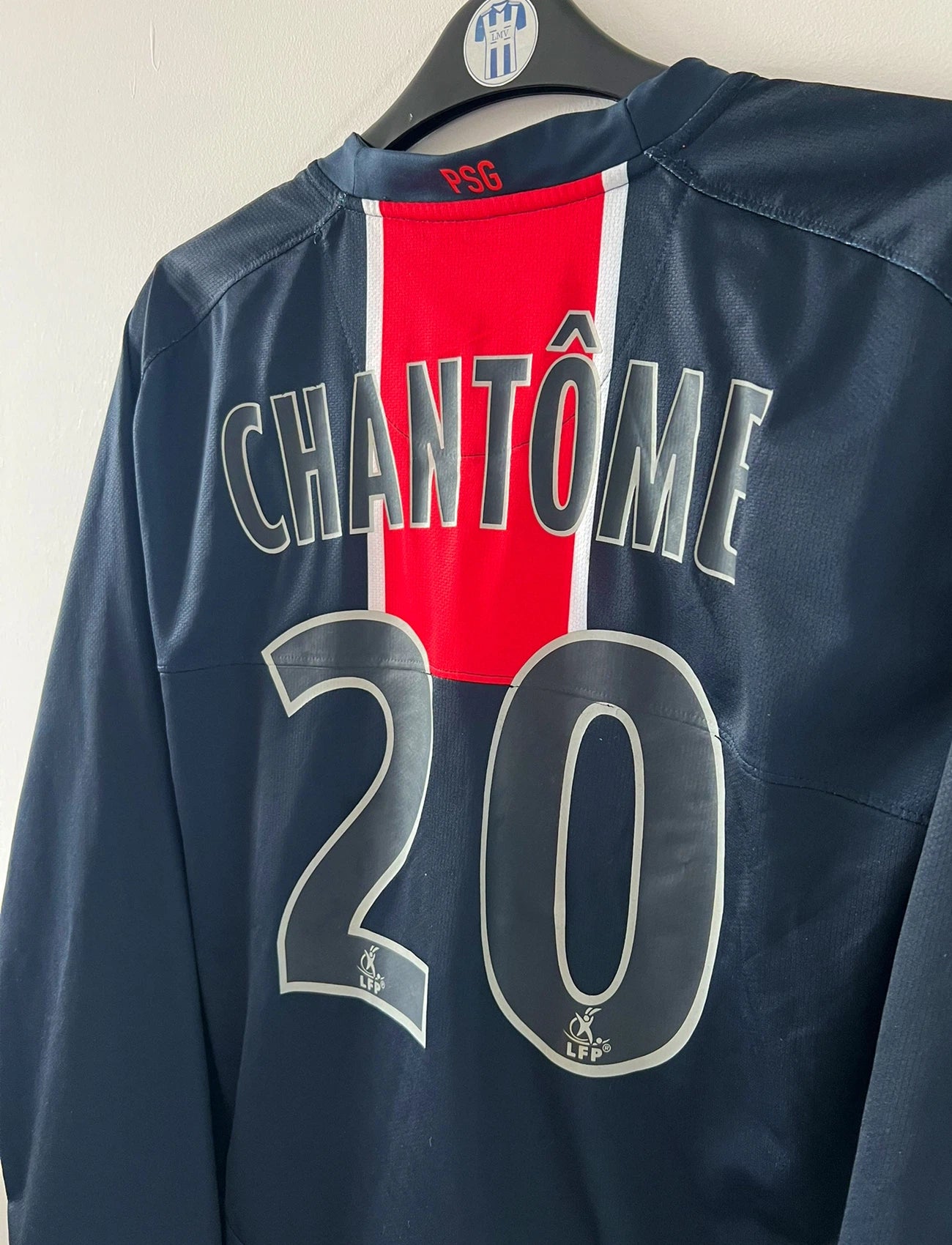 Maillot de foot vintage domicile bleu et rouge du PSG de la saison 2006/2007. On peut retrouver l'équipementier Nike et le sponsor Fly Emirates. Le Maillot est floqué du numéro 20 Chantôme. Il s'agit d'un maillot authentique d'époque.