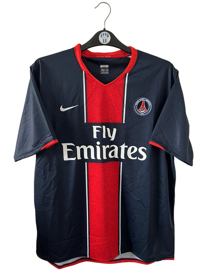 Maillot de foot vintage domicile bleu et rouge du PSG 2007/2008. On peut retrouver l'équipementier Nike et le sponsor Fly Emirates. Il s'agit d'un maillot authentique d'époque.