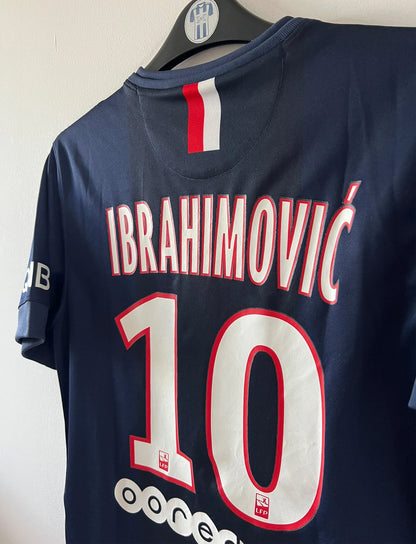 Maillot de foot vintage domicile bleu du PSG 2014/2015. On peut retrouver l'équipementier Nike et le sponsor Fly Emirates. Le maillot est floqué du numéro 10 Zlatan Ibrahimovic. Il s'agit d'un maillot authentique d'époque.