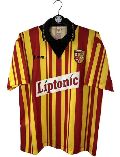 Maillot de foot vintage domicile rouge et jaune du RC Lens de la saison 1994/1995. On peut retrouver l'équipementier Olympic et le sponsor Liptonic. Il s'agit d'un maillot authentique d'époque.