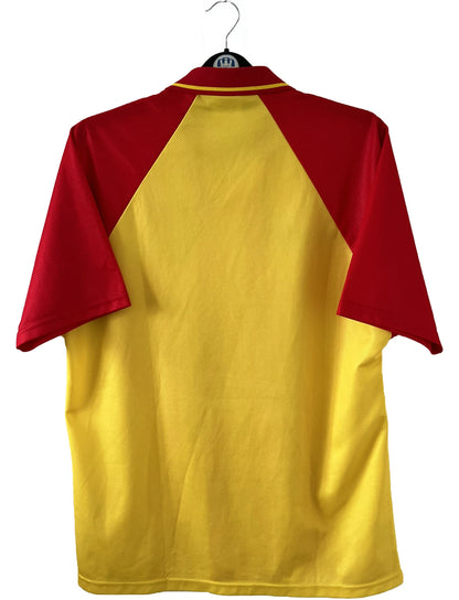 Maillot de foot vintage domicile rouge et jaune du RC Lens de la saison 1998/1999. On peut retrouver l'équipementier Umbro et le sponsor OLA. Il s'agit d'un maillot authentique d'époque.