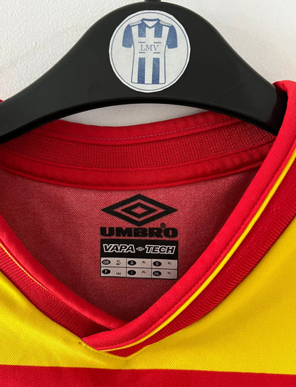 Maillot foot vintage rouge et jaune du RC Lens de la saison 2000/2001. On peut retrouver l'équipementier Umbro et le sponsor OLA. Il s'agit d'un maillot authentique d'époque.