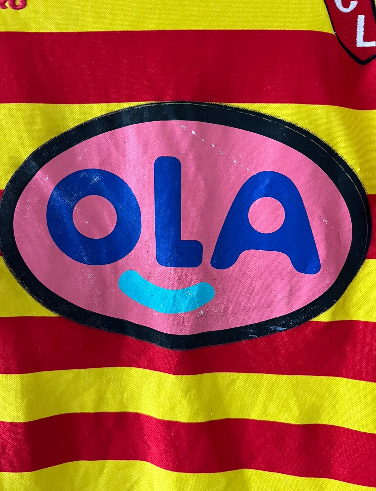 Maillot foot vintage rouge et jaune du RC Lens de la saison 2000/2001. On peut retrouver l'équipementier Umbro et le sponsor OLA. Il s'agit d'un maillot authentique d'époque.