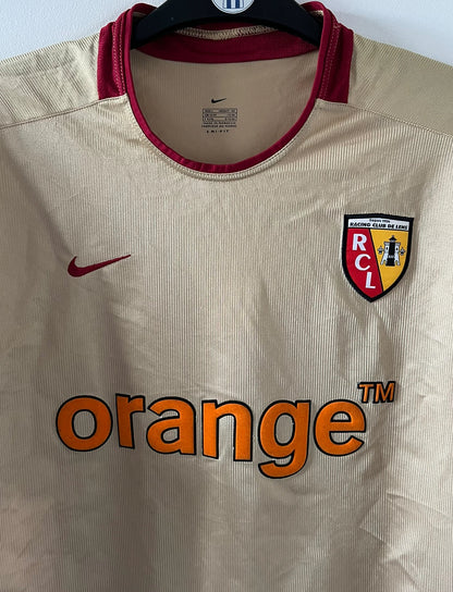 Maillot de foot vintage domicile doré du RC Lens de la saison 2002/2003. On peut retrouver l'équipementier Nike et le sponsor Orange. Il s'agit d'un maillot authentique d'époque.
