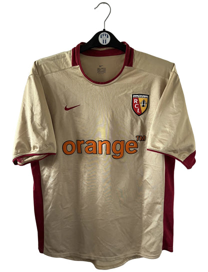 Maillot de foot vintage domicile doré du RC Lens de la saison 2002/2003. On peut retrouver l'équipementier Nike et le sponsor Orange. Il s'agit d'un maillot authentique d'époque.