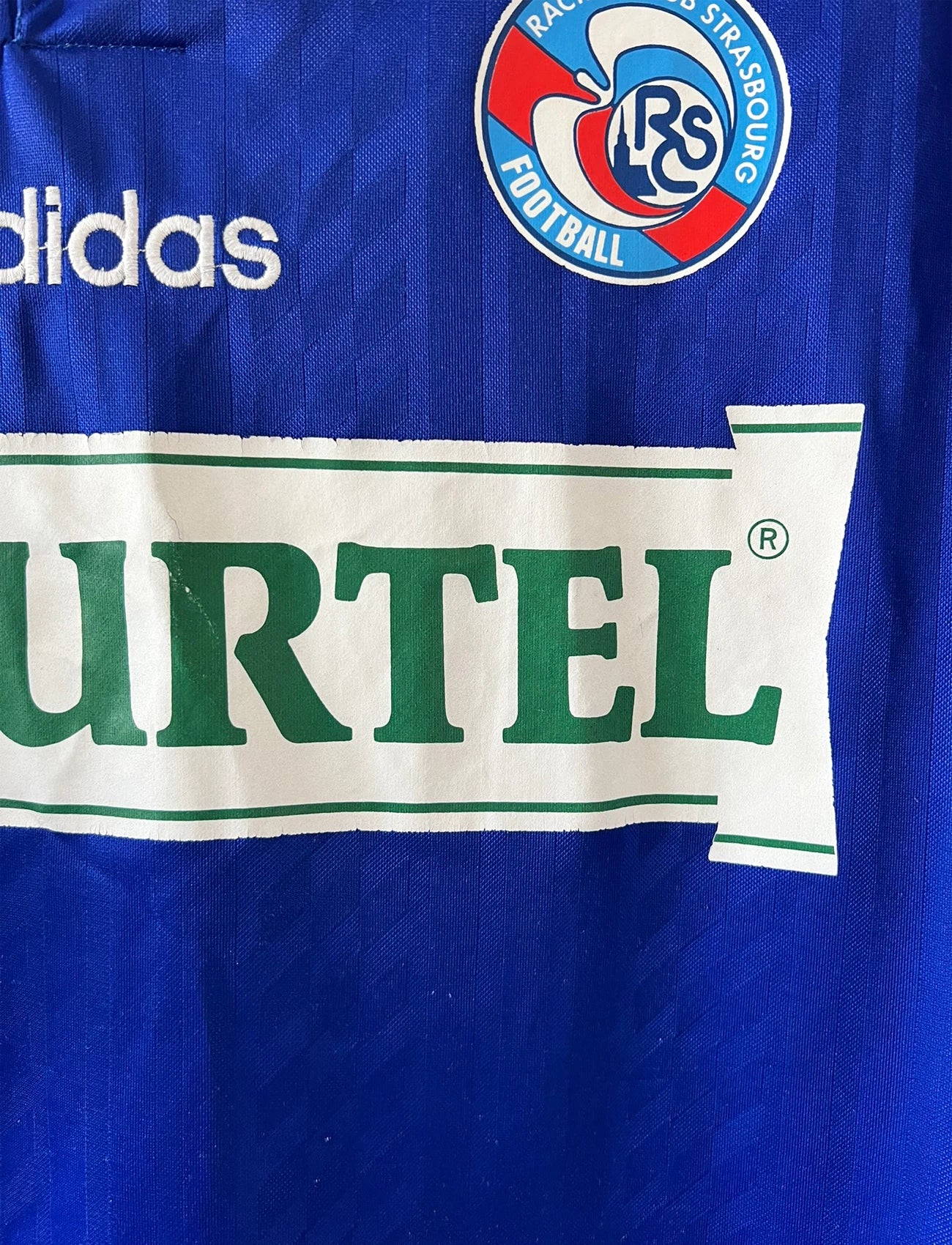 Maillot de foot vintage domicile bleu du RC Strasbourg de la saison 1994/1995. On peut retrouver l'équipementier Adidas et le sponsor Tourtel. Il s'agit d'un maillot authentique d'époque.