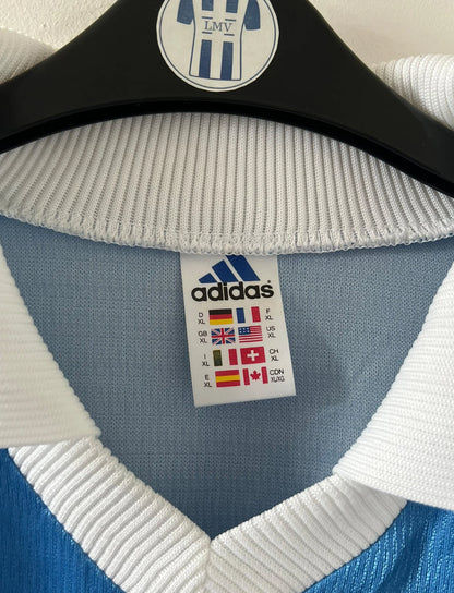 Maillot de foot vintage domicile bleu de strasbourg de la saison 1999/2000. On peut retrouver l'équipementier Adidas et le sponsor Canal+. Il s'agit d'un maillot authentique d'époque, issu du stock pro du club