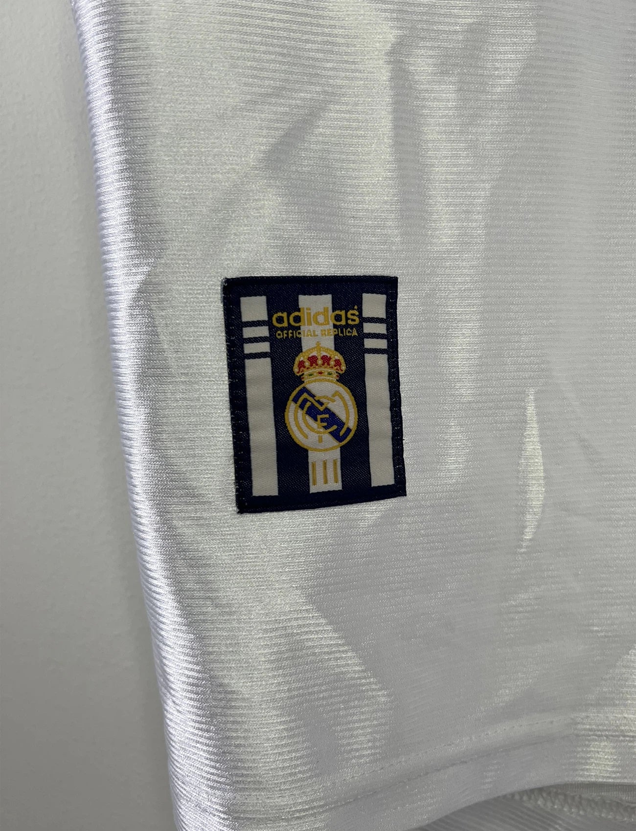 Maillot de foot vintage domicile blanc du Real Madrid de la saison 1998/1999. On peut retrouver l'équipementier Adidas et le sponsor Teka. Il s'agit d'un maillot authentique d'époque.