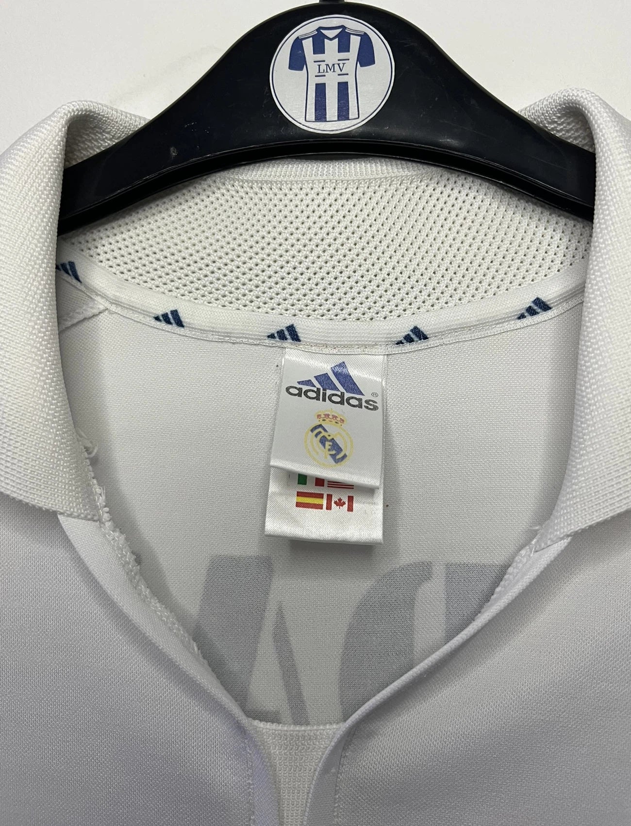 Maillot de foot vintage domicile du real madrid de la saison 2001-2002. Le maillot est de couleur blanc et noir. On peut retrouver l'équipementier adidas et le sponsor Real Madrid.com. Le maillot est floqué du numéro 5 Zinedine Zidane. Il s'agit d'un maillot authentique comportant les numéros 695856