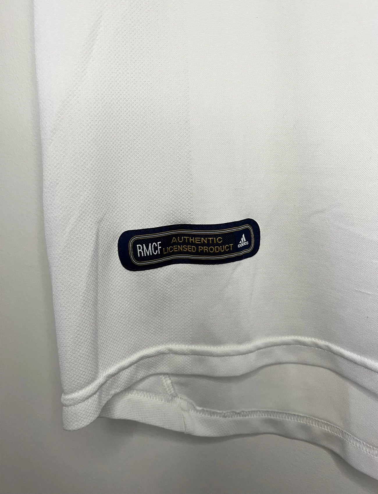 Maillot de foot vintage domicile du real madrid de la saison 2001-2002. Le maillot est de couleur blanc et noir. On peut retrouver l'équipementier adidas et le sponsor Real Madrid.com. Le maillot est floqué du numéro 5 Zinedine Zidane. Il s'agit d'un maillot authentique comportant les numéros 695856