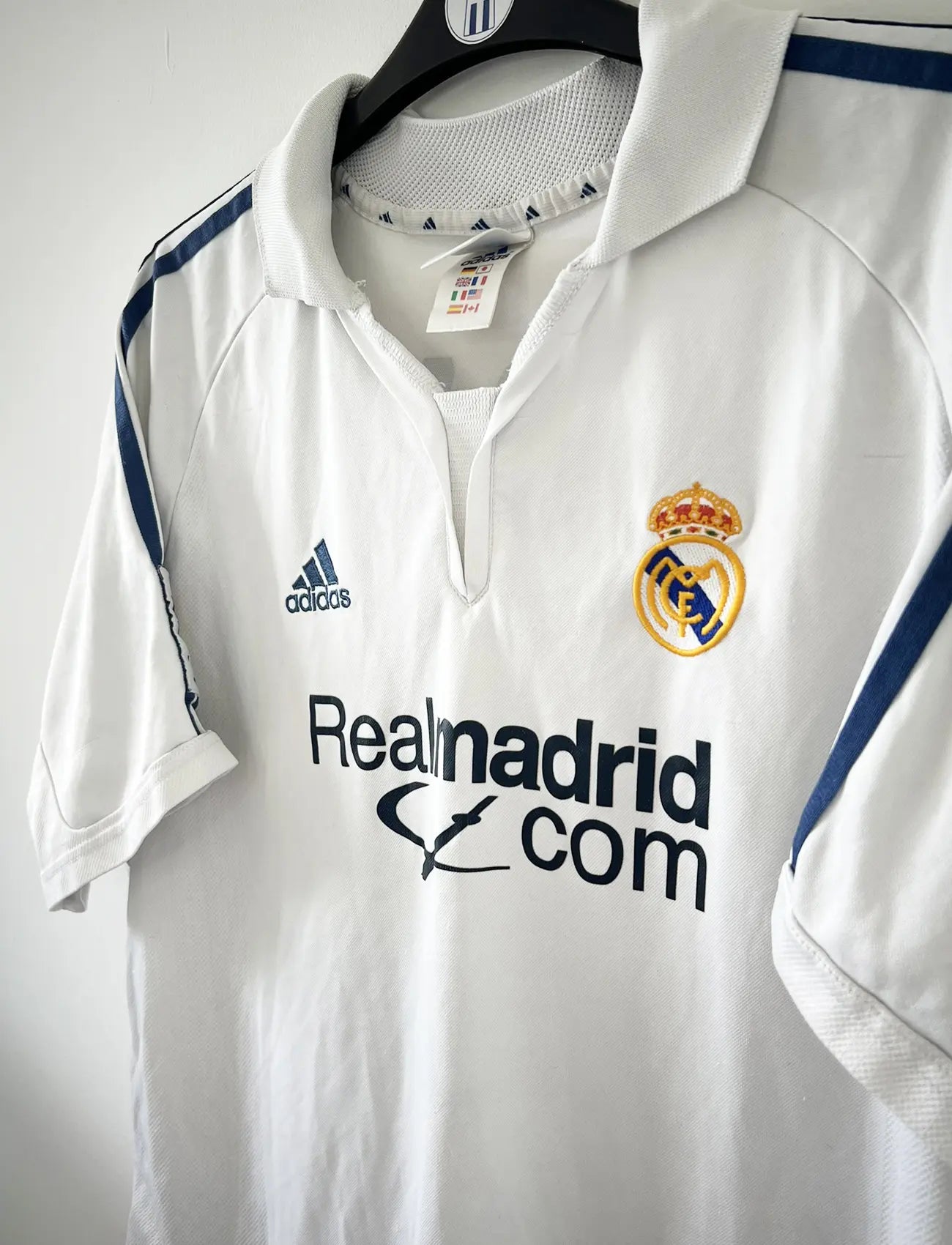 Maillot de foot vintage domicile du real madrid de la saison 2001-2002. Le maillot est de couleur blanc et noir. On peut retrouver l'équipementier adidas et le sponsor Real Madrid.com. Le maillot est floqué du numéro 5 Zinedine Zidane. Il s'agit d'un maillot authentique comportant les numéros 695856