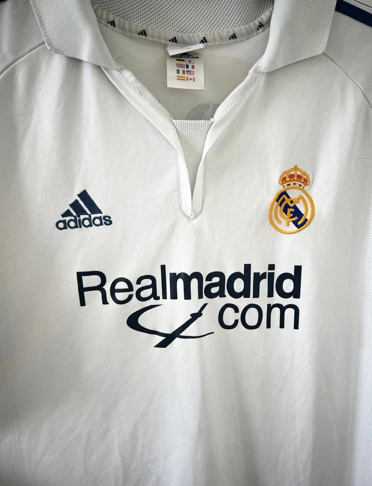 Maillot de foot vintage domicile du real madrid de la saison 2001-2002. Le maillot est de couleur blanc et noir. On peut retrouver l'équipementier adidas et le sponsor Real Madrid.com. Le maillot est floqué du numéro 5 Zinedine Zidane. Il s'agit d'un maillot authentique comportant les numéros 695856
