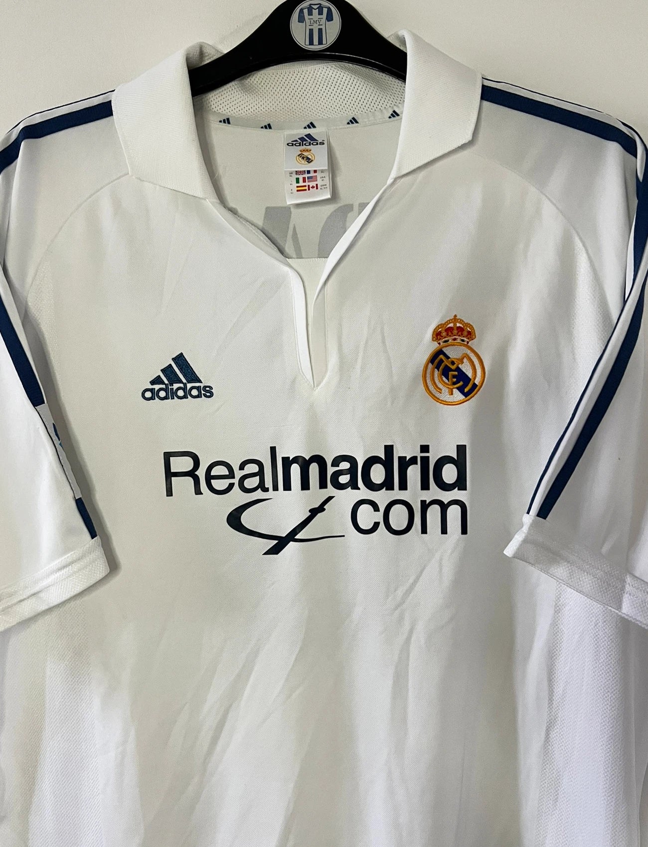 Maillot de foot vintage domicile blanc du real madrid de la saison 2001/2002. On peut retrouver l'équipementier Adidas et le sponsor Real madrid.com. Le maillot est floqué du numéro 5 Zinedine Zidane. Il s'agit d'un maillot authentique d'époque.