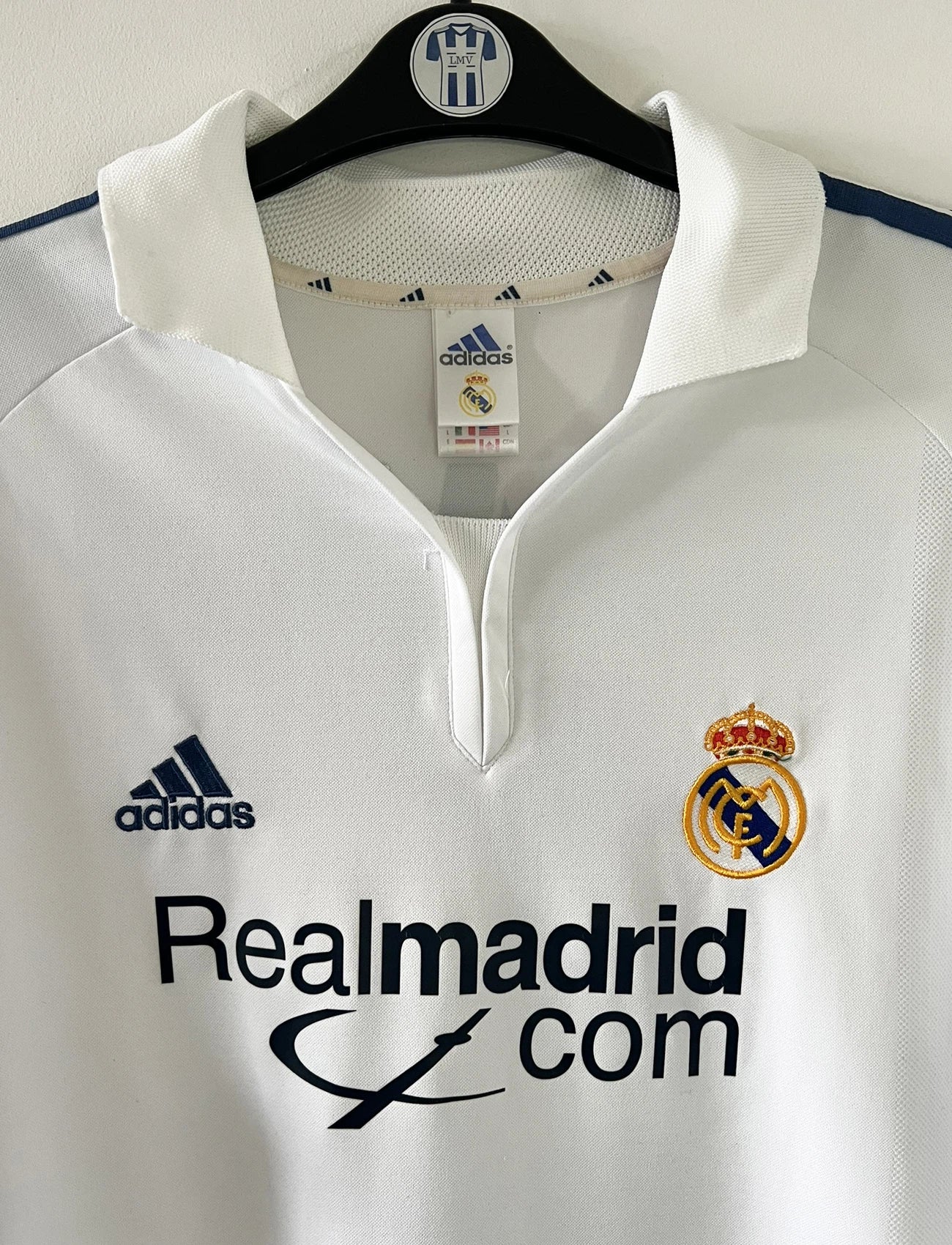 Maillot de foot vintage domicile du real madrid de la saison 2001-2002. Le maillot est de couleur blanc et noir. On peut retrouver l'équipementier adidas et le sponsor Real Madrid.com. Le maillot est floqué du numéro 5 Zinedine Zidane. Il s'agit d'un maillot authentique comportant les numéros 695856