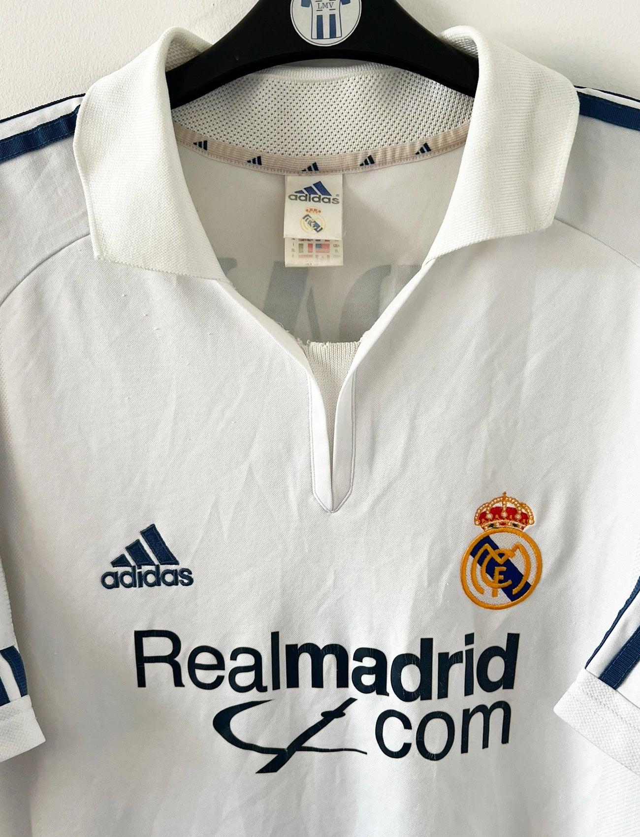 Maillot de foot vintage domicile blanc du real madrid de la saison 2001/2002. On peut retrouver l'équipementier Adidas et le sponsor Real madrid.com. Le maillot est floqué du numéro 5 Zinedine Zidane. Il s'agit d'un maillot authentique d'époque.