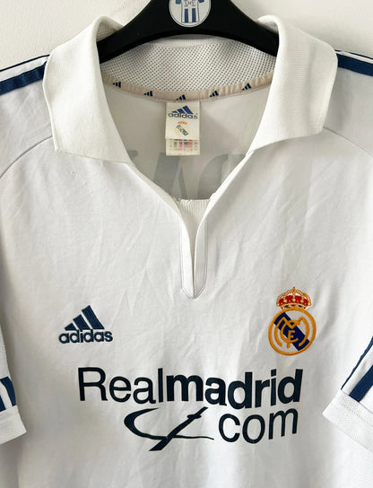Maillot de foot vintage domicile blanc du real madrid de la saison 2001/2002. On peut retrouver l'équipementier Adidas et le sponsor Real madrid.com. Le maillot est floqué du numéro 5 Zinedine Zidane. Il s'agit d'un maillot authentique d'époque.