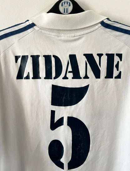 Maillot de foot vintage domicile blanc du real madrid de la saison 2001/2002. On peut retrouver l'équipementier Adidas et le sponsor Real madrid.com. Le maillot est floqué du numéro 5 Zinedine Zidane. Il s'agit d'un maillot authentique d'époque.