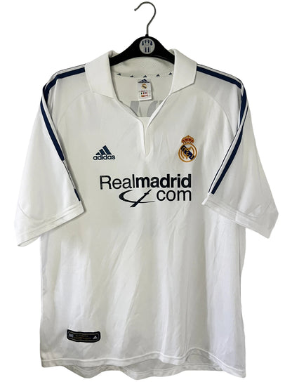 Maillot de foot vintage domicile blanc du real madrid de la saison 2001/2002. On peut retrouver l'équipementier Adidas et le sponsor Real madrid.com. Le maillot est floqué du numéro 5 Zinedine Zidane. Il s'agit d'un maillot authentique d'époque.