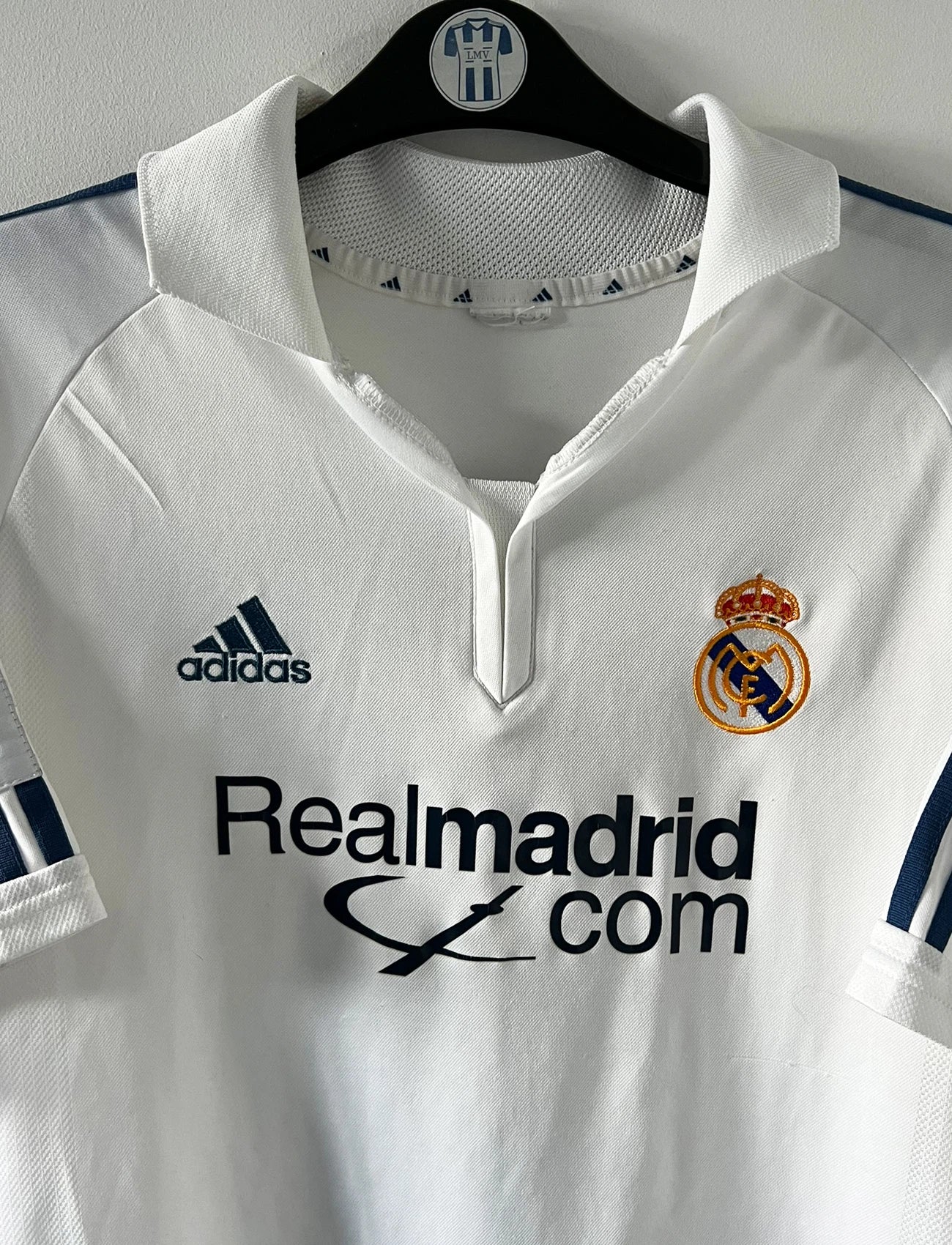 Maillot de foot vintage domicile blanc du real madrid de la saison 2001/2002. On peut retrouver l'équipementier Adidas et le sponsor Real Madrid.com. Le maillot est floqué du numéro 5 Zinedine Zidane. Il s'agit d'un maillot authentique d'époque.