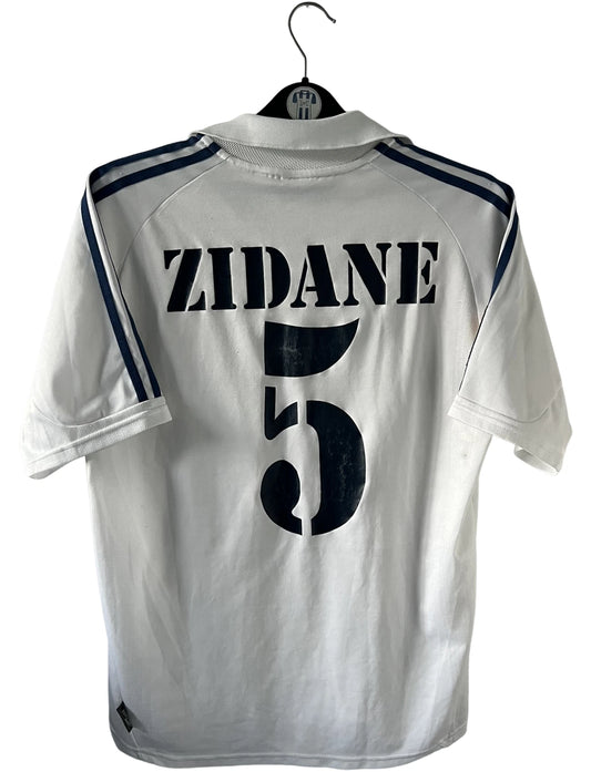 Maillot de foot vintage domicile blanc du real madrid de la saison 2001/2002. On peut retrouver l'équipementier Adidas et le sponsor Real Madrid.com. Le maillot est floqué du numéro 5 Zinedine Zidane. Il s'agit d'un maillot authentique d'époque.