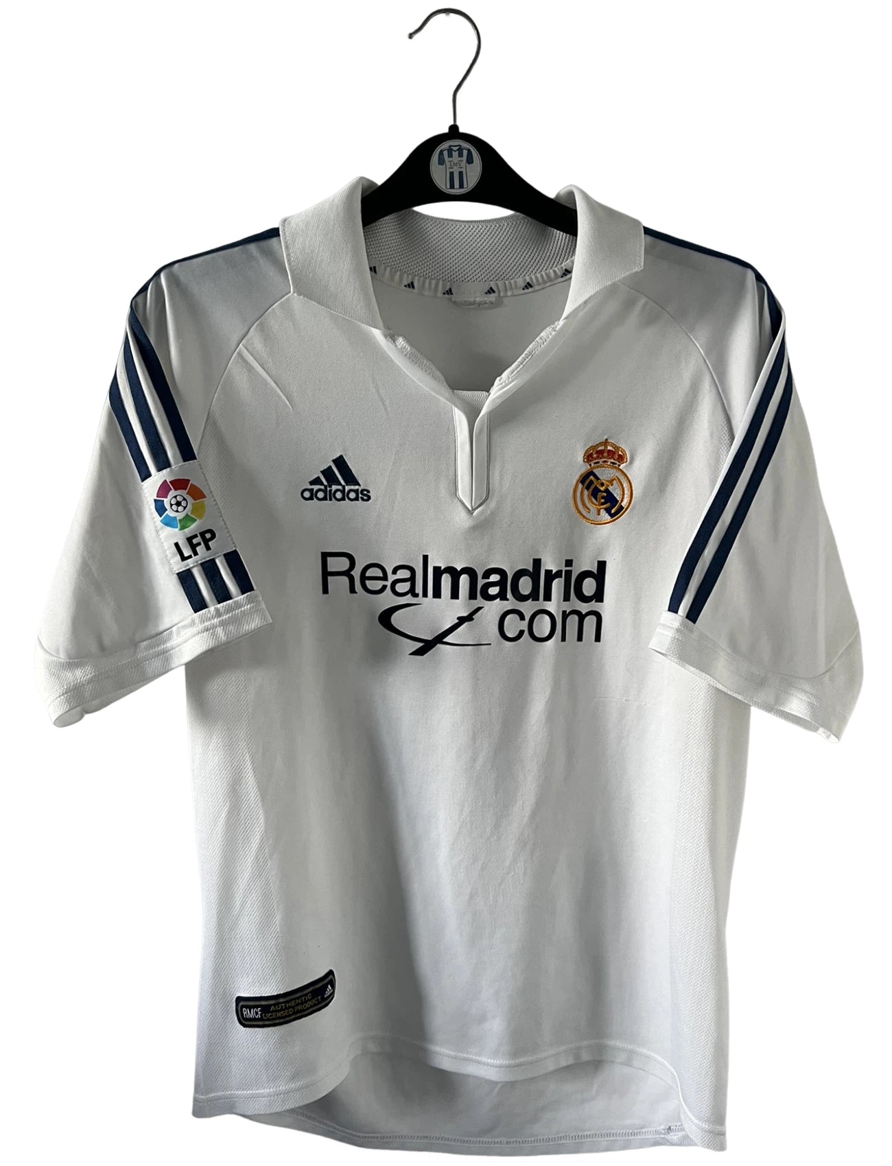 Maillot de foot vintage domicile blanc du real madrid de la saison 2001/2002. On peut retrouver l'équipementier Adidas et le sponsor Real Madrid.com. Le maillot est floqué du numéro 5 Zinedine Zidane. Il s'agit d'un maillot authentique d'époque.