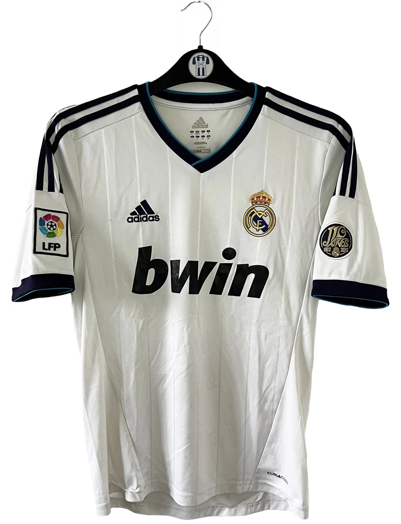 Maillot de foot vintage domicile blanc du real madrid de la saison 2012/2013. On peut retrouver l'équipementier adidas et le sponsor bwin. Le maillot est floqué du numéro 7 Cristiano Ronaldo. Il s'agit d'un maillot authentique comportant les numéros X21987.