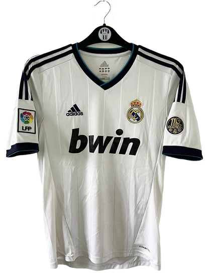 Maillot de foot vintage domicile blanc du real madrid de la saison 2012/2013. On peut retrouver l'équipementier adidas et le sponsor bwin. Le maillot est floqué du numéro 7 Cristiano Ronaldo. Il s'agit d'un maillot authentique comportant les numéros X21987.