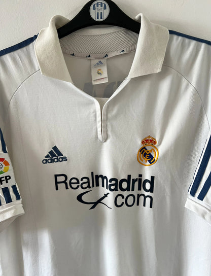 Maillot de foot vintage domicile blanc du Real Madrid de la saison 2001/2002. On peut retrouver l'équipementier Adidas et le sponsor Real Madrid.com. Le maillot est floqué du numéro 5 Zinedine Zidane. Il s'agit d'un maillot authentique d'époque.