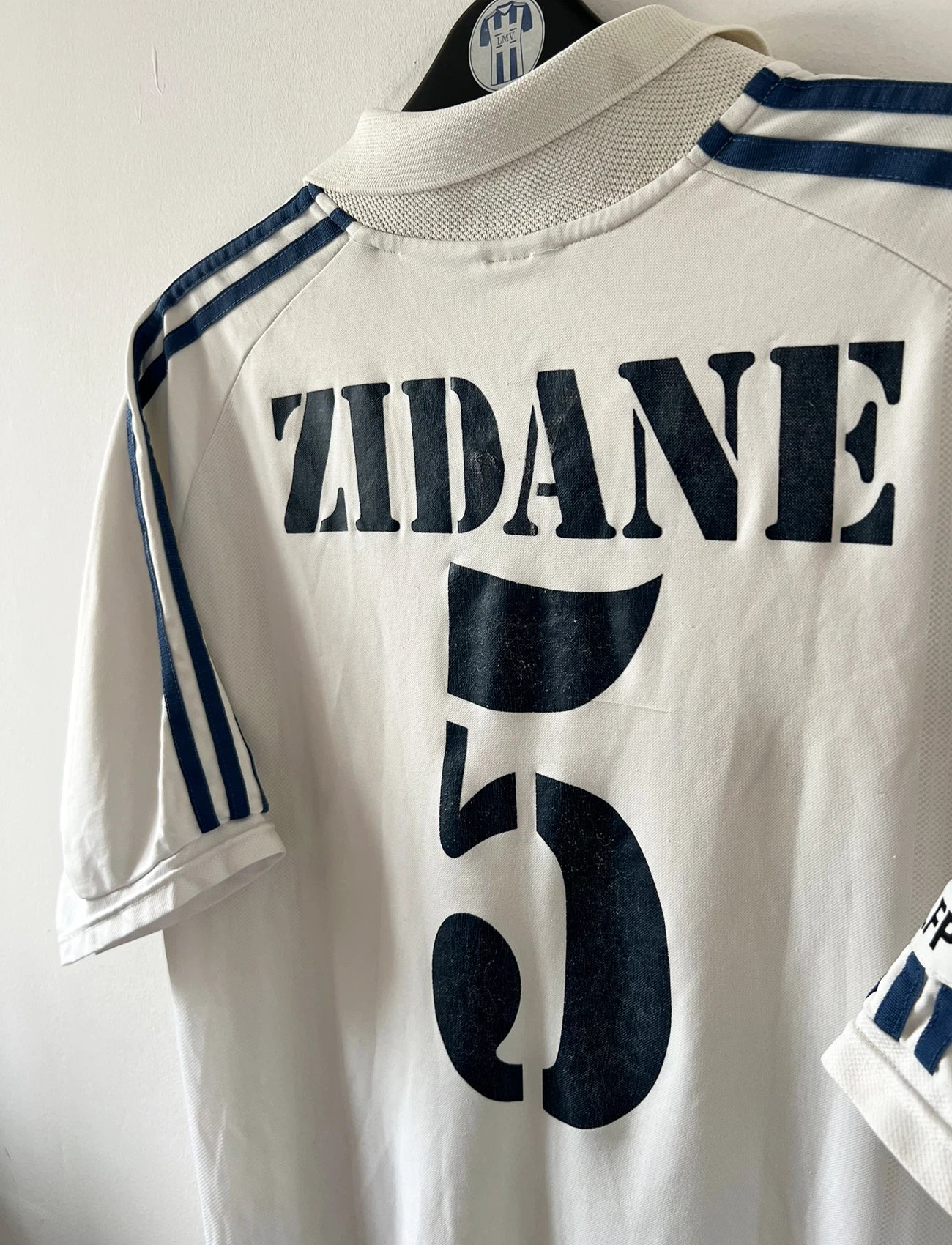 Maillot de foot vintage domicile blanc du Real Madrid de la saison 2001/2002. On peut retrouver l'équipementier Adidas et le sponsor Real Madrid.com. Le maillot est floqué du numéro 5 Zinedine Zidane. Il s'agit d'un maillot authentique d'époque.